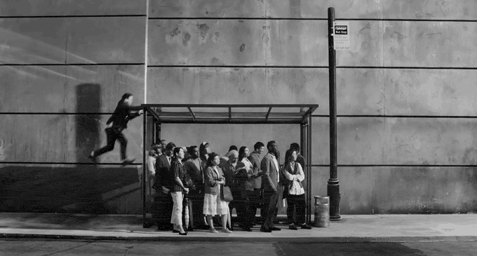 Black and white: a man bounces onto the roof of a crowded bus shelter in Oscar Hudson's Bounce for Apple