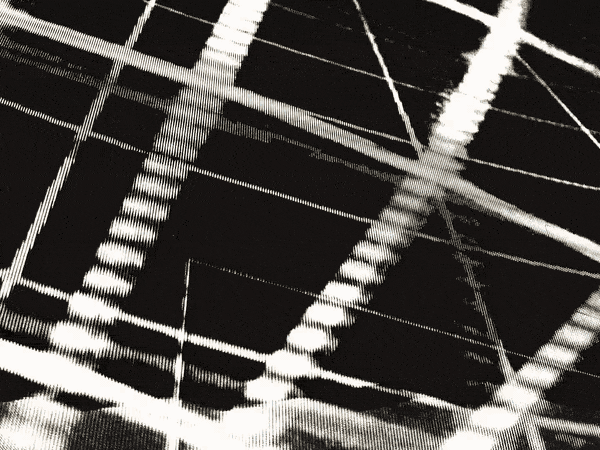 Sepia toned: concert light rigs strobe in a symmetrical V while beams sweep over a festival stage