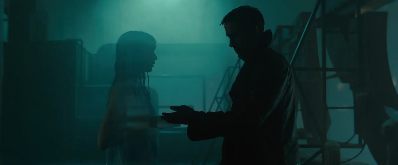 Two figures in a misty teal-blue interior