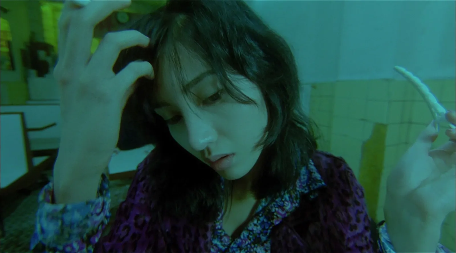A woman in a teal-green room shot with an extreme wide-angle lens