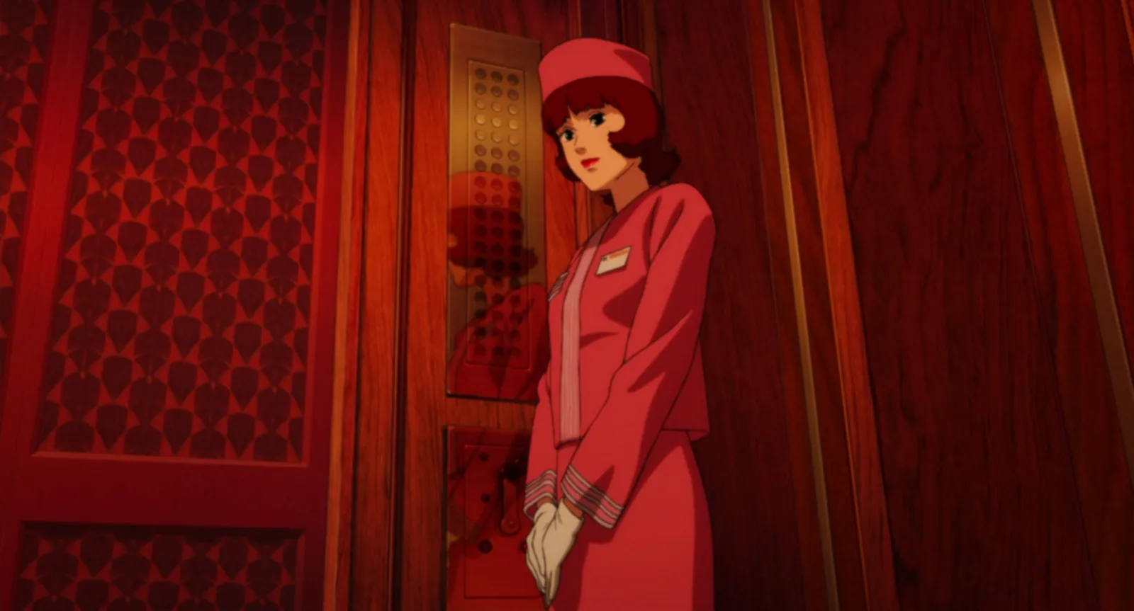 A woman in a pink bellhop uniform standing beside an ornate red lift