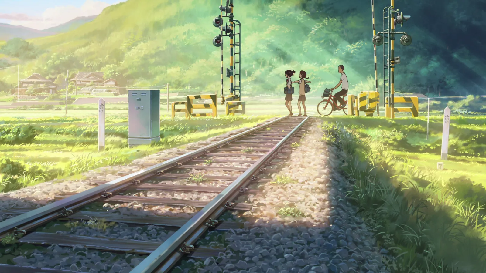 Railway tracks through a sunlit green valley with schoolkids at a crossing